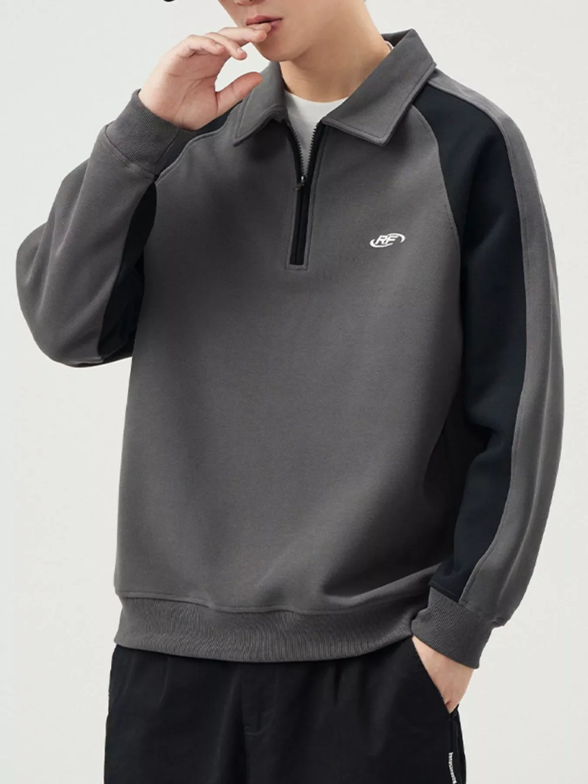 Plus-size dark gray raglan sweatshirt with black sleeves and quarter zip neckline.