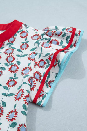 Cotton blouse with red and blue floral print, ruffle sleeves, and contrast trim.