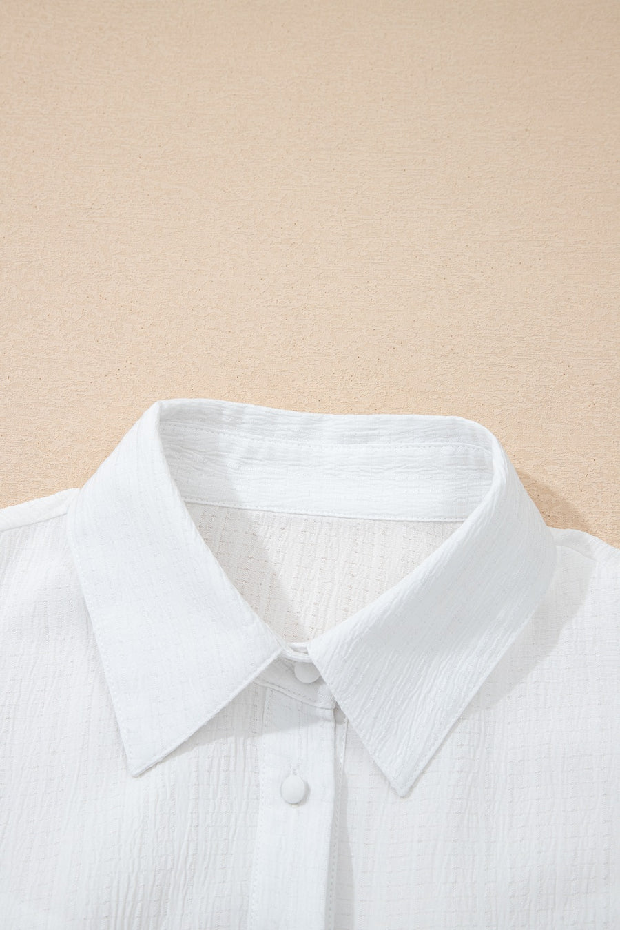 White crinkled texture button-down shirt with classic collar and button detail.