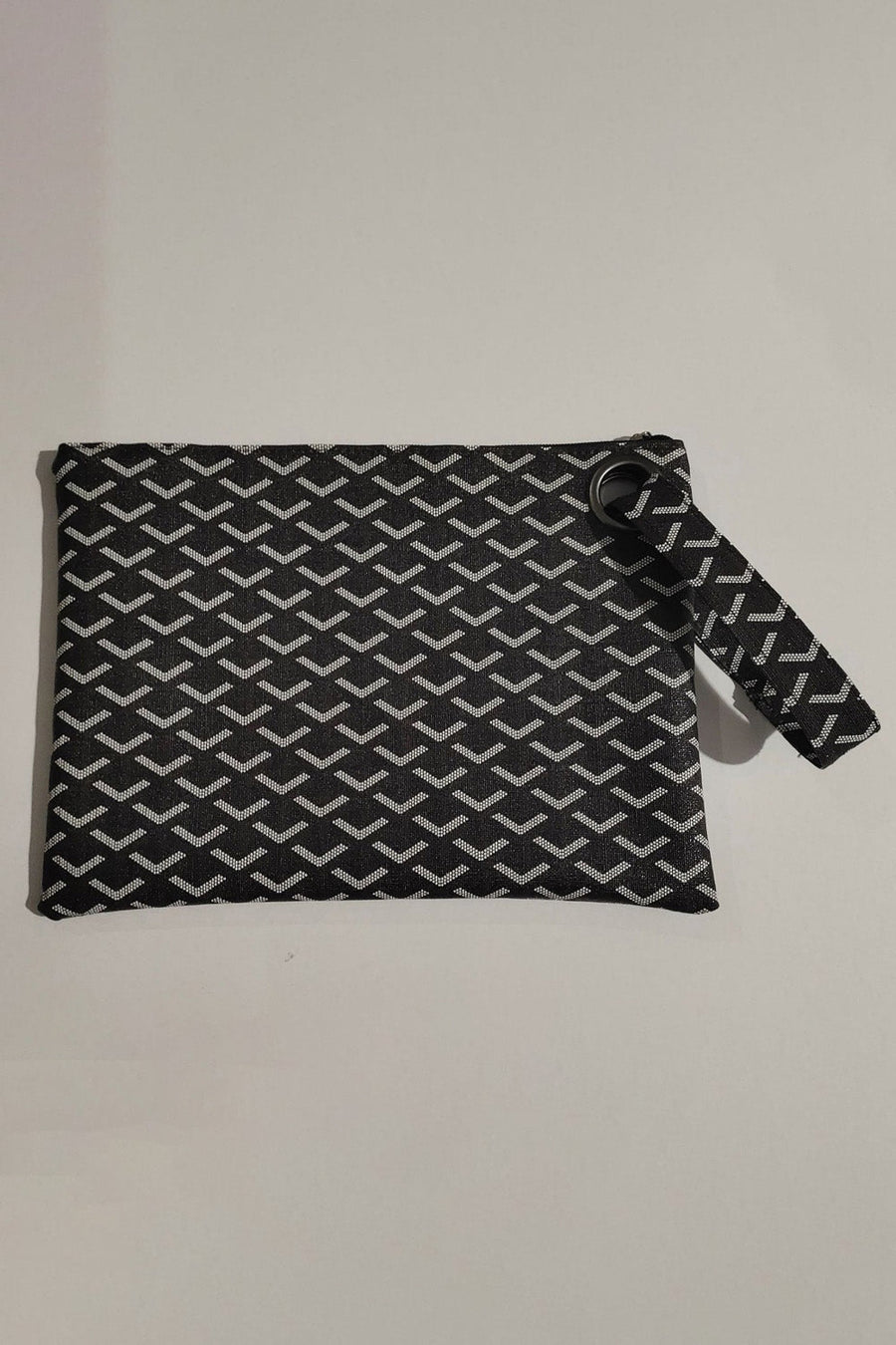 Black clutch bag with geometric pattern and grommet detail wristlet strap