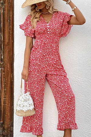 Floral smocked bodice jumpsuit with flutter sleeves and decorative buttons.