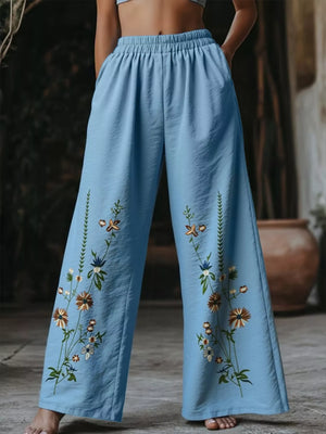 Sky blue wide-leg trousers with embroidered floral details and elastic waist.