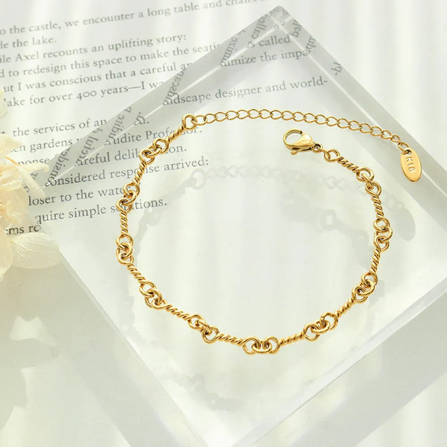 Gold twisted chain link bracelet with adjustable clasp and 18K gold plating.