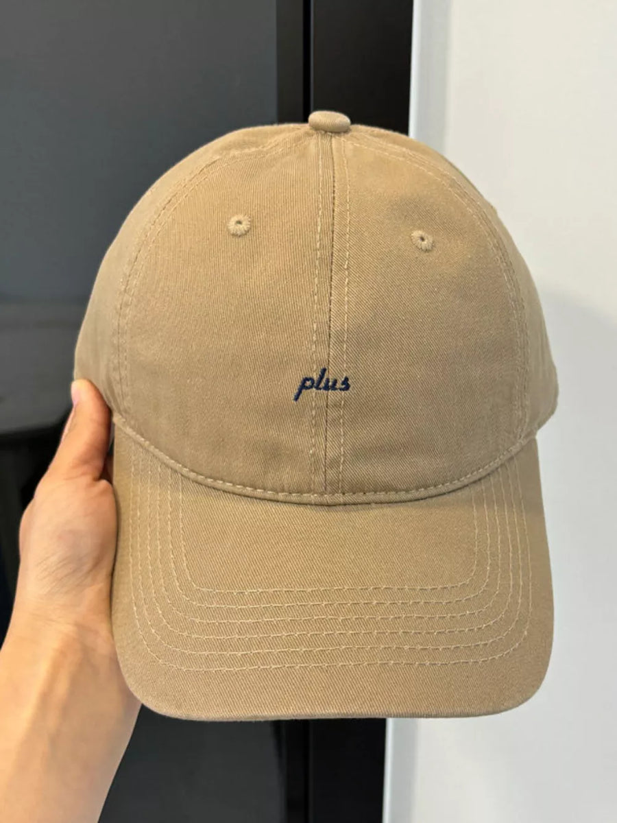 Khaki baseball cap with embroidered blue "plus" text detail