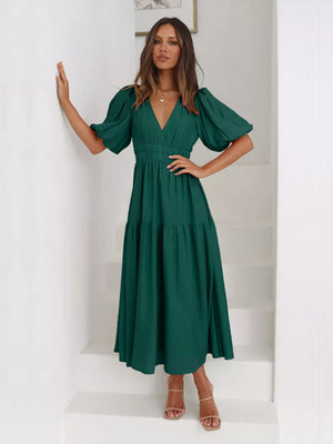 Dark green midi dress with puff sleeves and tiered skirt, V-neck, cinched waist.
