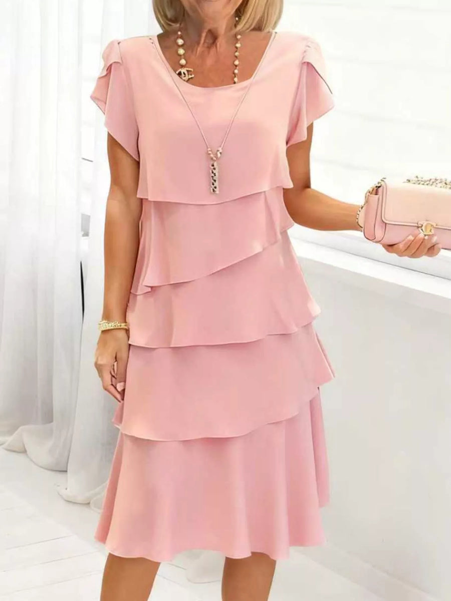 Blush pink tiered petal sleeve dress with ruffled layers and a scoop neckline.