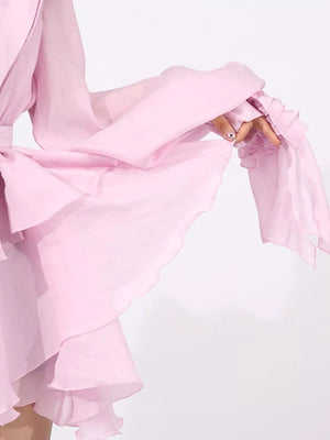 Pink tiered ruffle mini dress with ruffled sleeves and a tie waist.