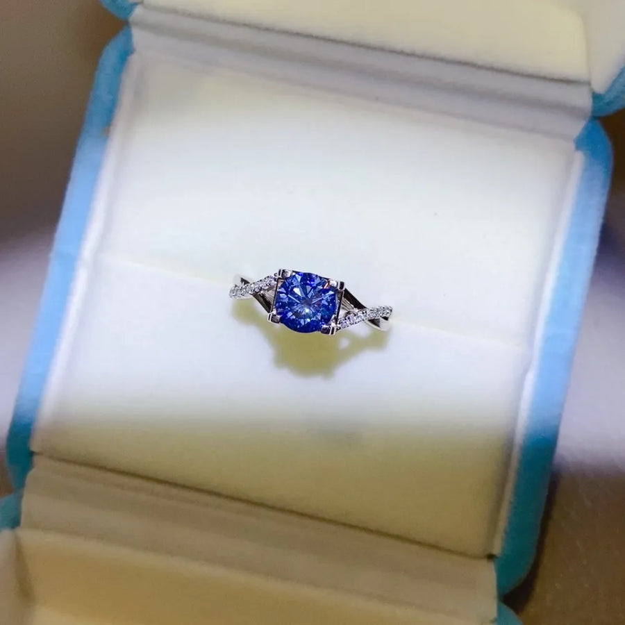 Silver twisted pavé moissanite engagement ring with blue center stone