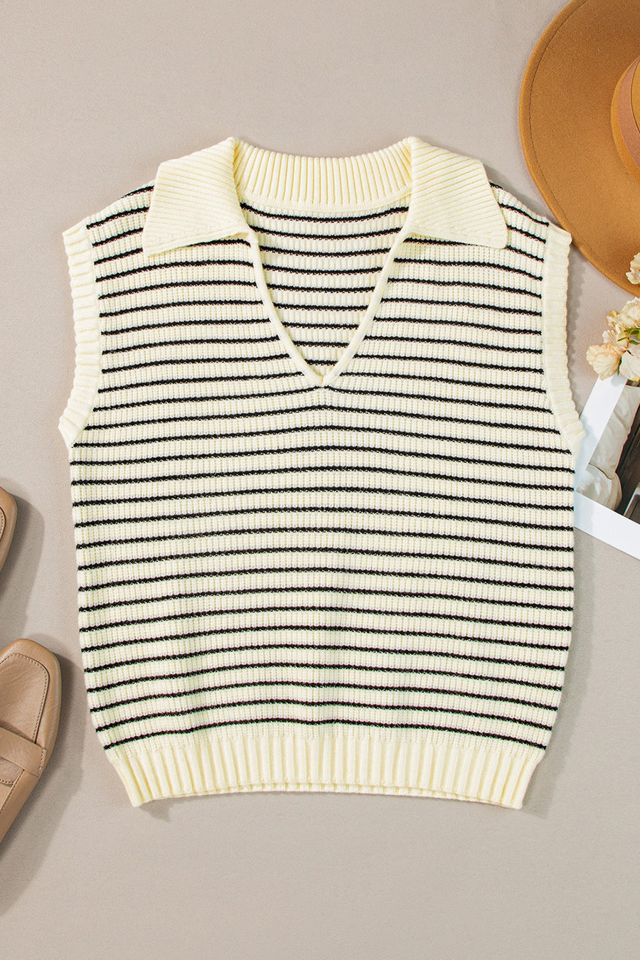 Striped knit polo vest in ivory with black stripes, featuring a V-neck and collar.