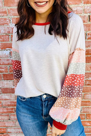 Cream waffle knit top with multicolor striped puff sleeves and red trim