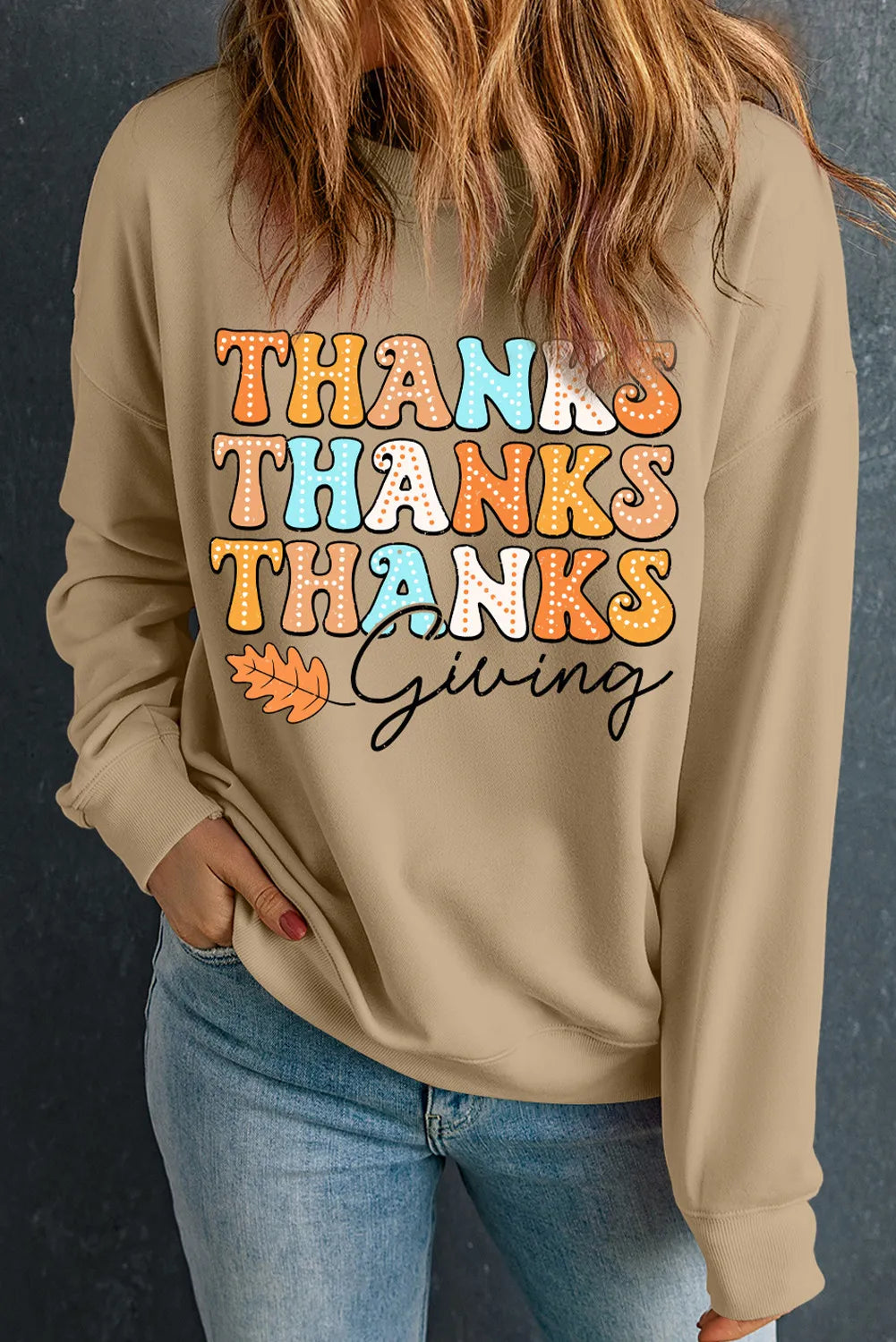 Khaki drop shoulder sweatshirt with "Thanksgiving" graphic and fall leaf detail.
