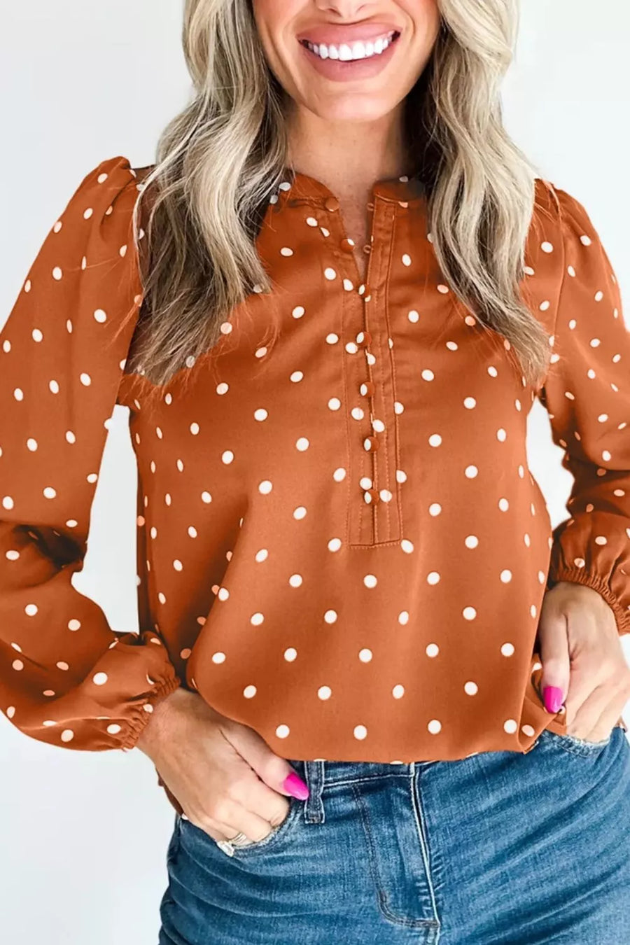 Brown polka dot v-neck shirt with decorative buttons and long sleeves.
