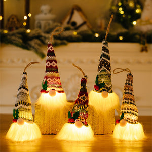 Illuminated gnome ornaments with knitted hats in red, white, and brown patterns, featuring fluffy white beards.
