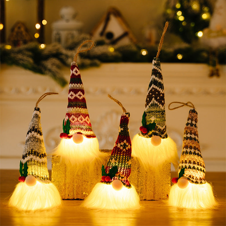 Illuminated gnome ornaments with knitted hats in red, white, and brown patterns, featuring fluffy white beards.