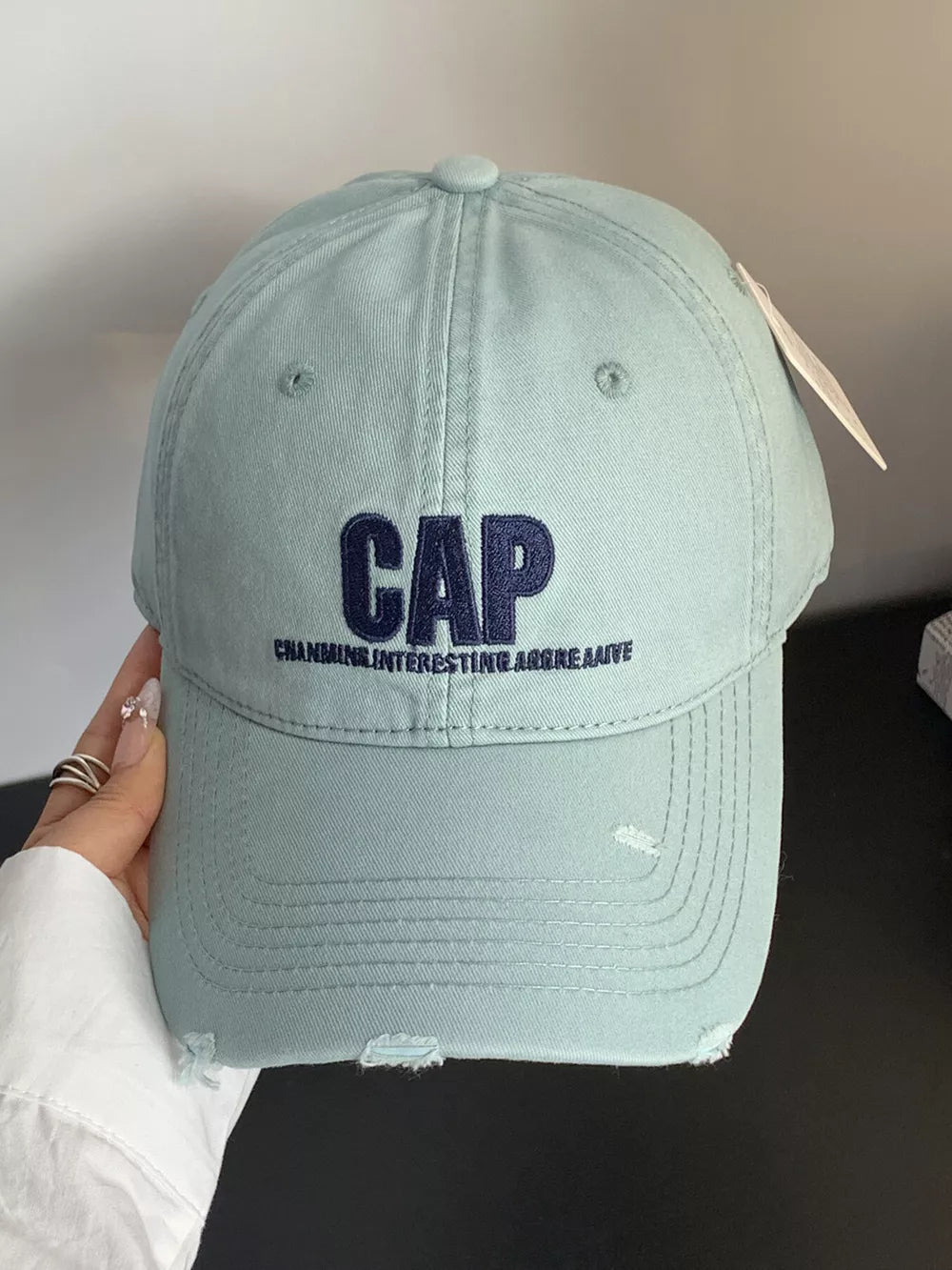 Mint green distressed cotton baseball hat with embroidered CAP and text.