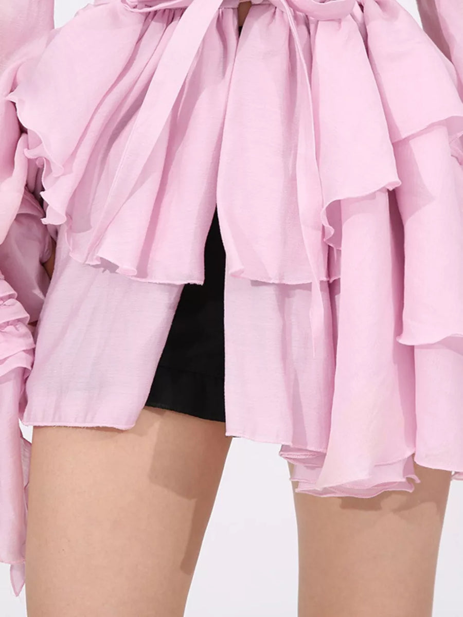 Pink tiered ruffle mini dress with button detail and tie neck.