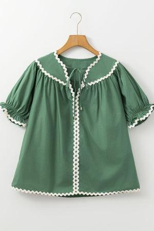 Moss green blouse with puff sleeves, tie neck, and white scalloped trim details.