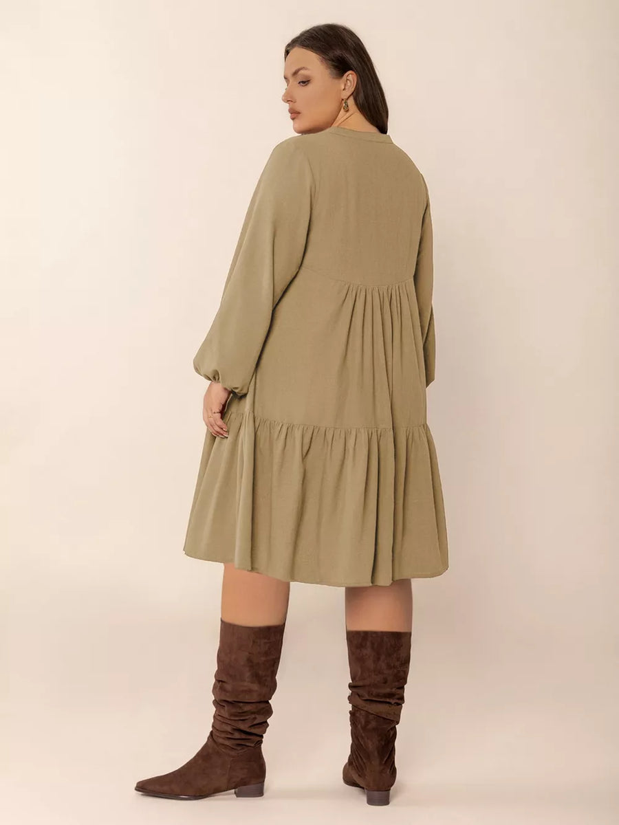 Olive green tie-neck dress with balloon sleeves, tiered skirt, and button front.
