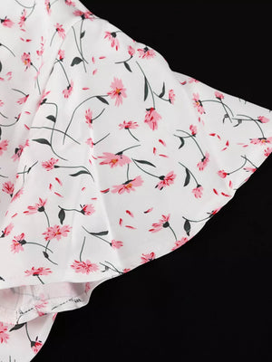 White dress with pink floral print and flutter sleeves.