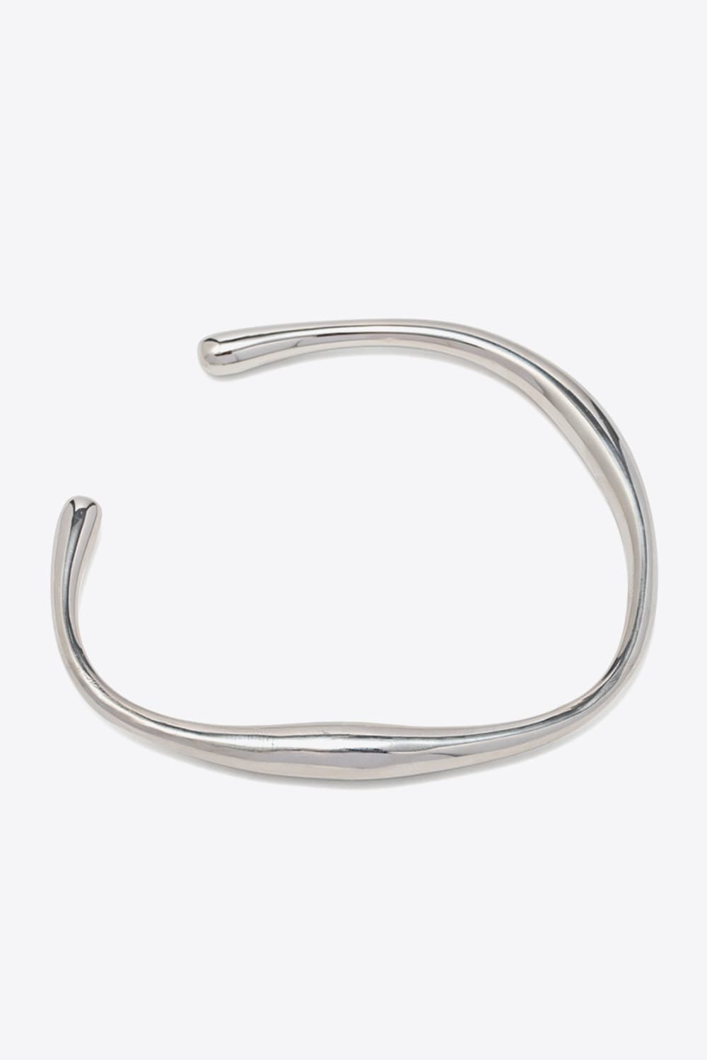 Sculpted silver open-ended bangle with a chic, fluid design.