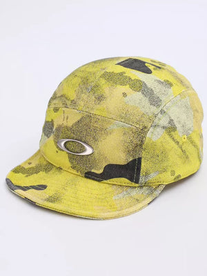 Oakley 5-panel hat with yellow and black abstract camouflage print and silver logo detail.
