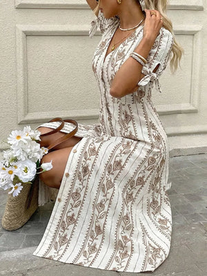 Printed button-down midi dress with tie sleeves and a-line cut in white with brown floral pattern.