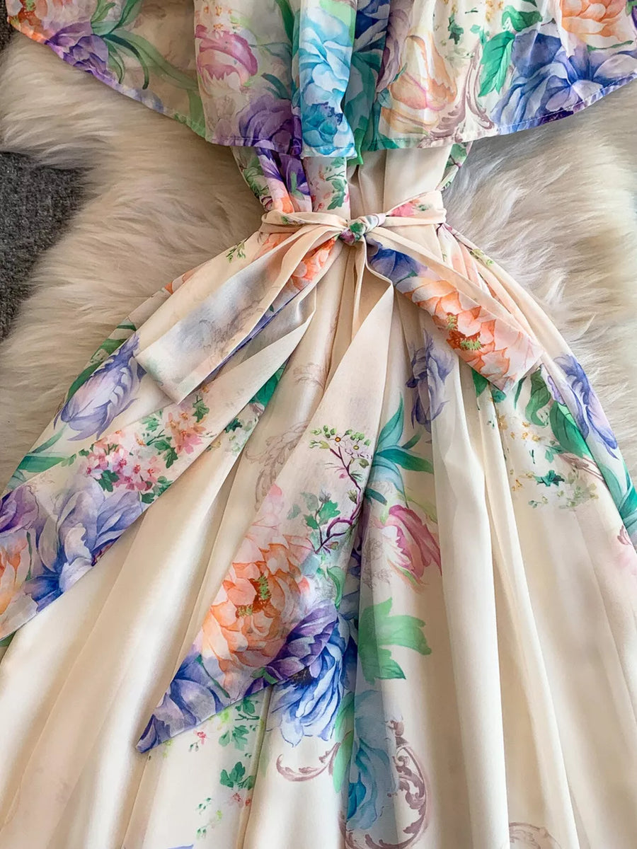 Botanical off-shoulder dress in light pink with floral print and belted waist detail.