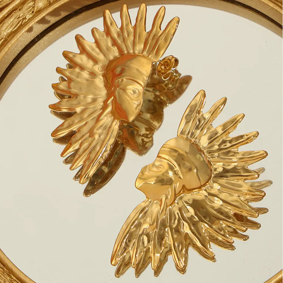Gold sculptural sunburst earrings with textured petals and a face detail.