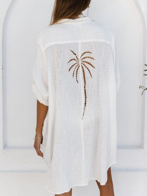 White cotton blend button-down shirt dress with palm tree cutout detail on back.