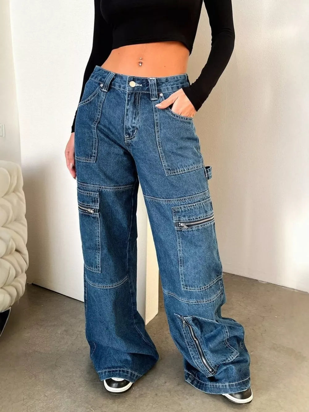 Dark blue denim wide leg cargo jeans with zipper pockets and a relaxed fit.