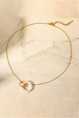 Gold necklace with interlocking pearl and twisted gold circles pendant