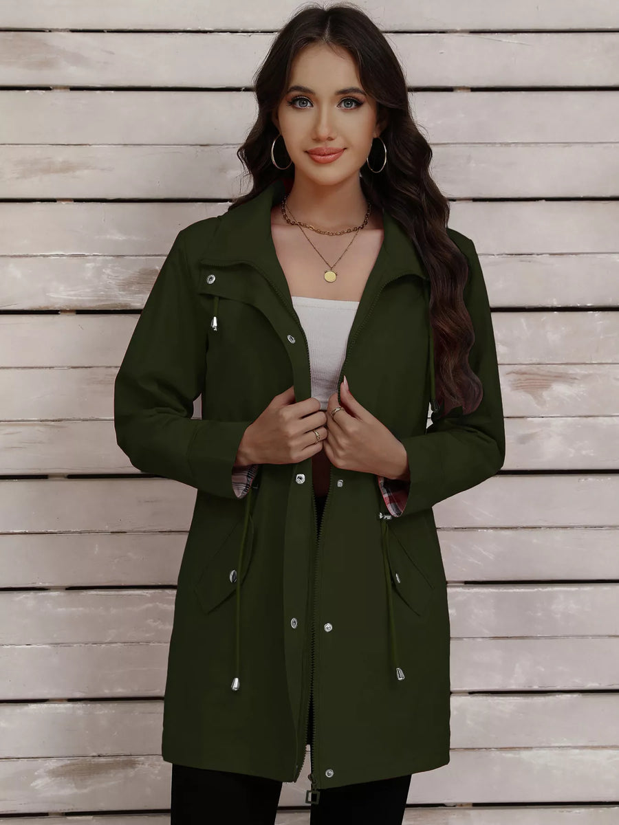 Military green drawstring trench coat with snap-down front and plaid lining detail.