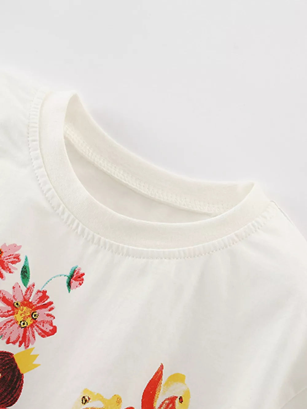 White cotton toddler t-shirt with colorful floral and fairy graphic print.