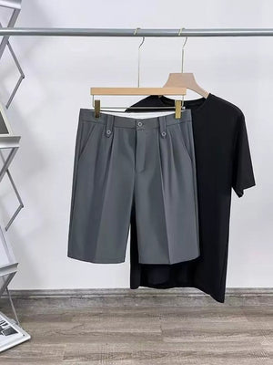 Dark gray pleated chino shorts with pockets and button closure, styled with a black t-shirt.