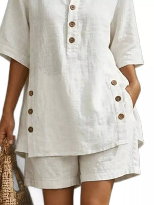 White linen shorts with button details and a matching button-up top with short sleeves.