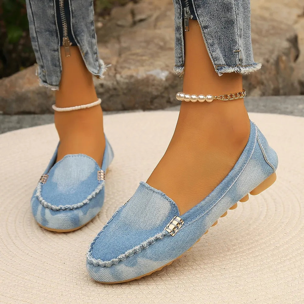 Denim loafers in light blue with contrast stitching and metal detail.