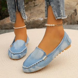 Denim loafers in light blue with contrast stitching and metal detail.