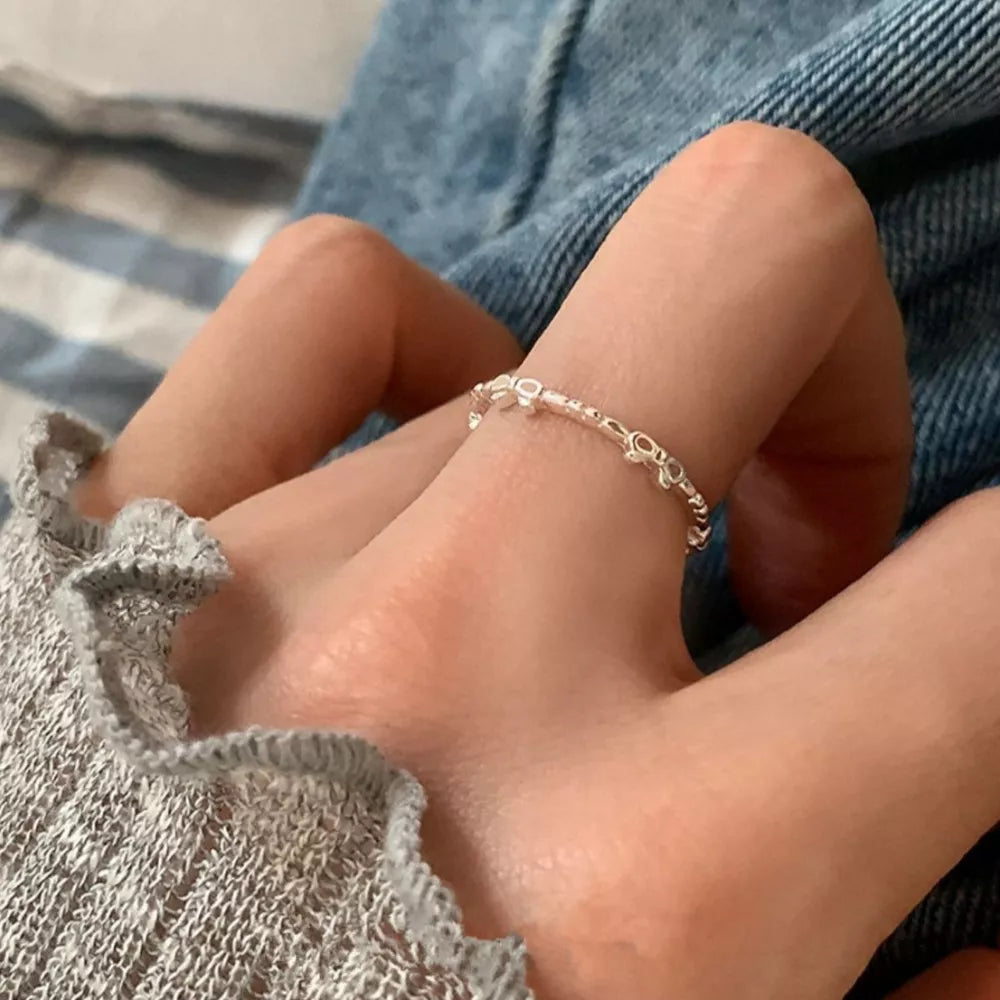 Delicate sterling silver ring with a dainty bow pattern.