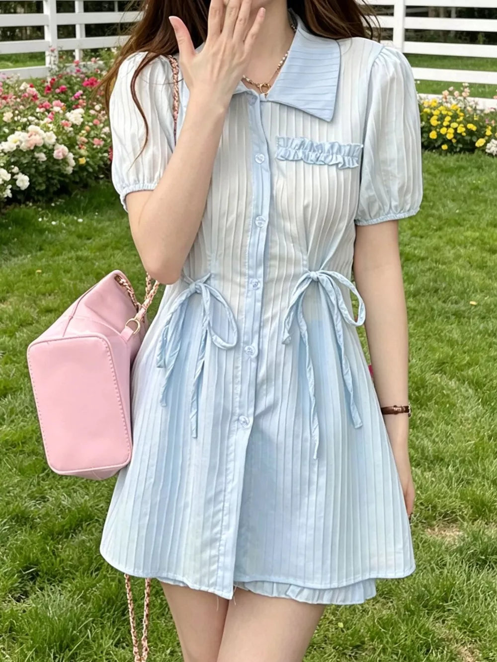 Light blue ruffled button-down shirt dress with cinched waist ties and puff sleeves.