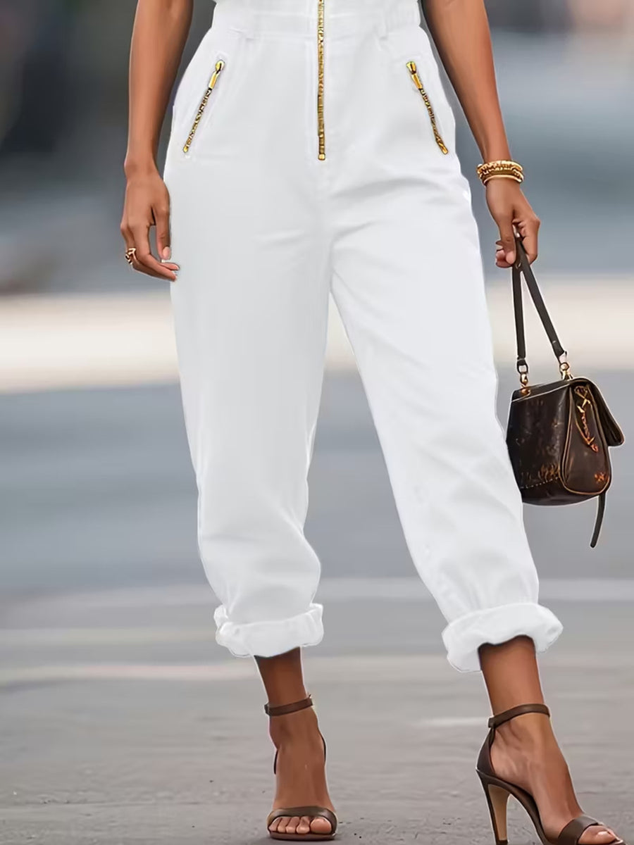 White zip-up romper with gold zipper pockets and cuffed ankles