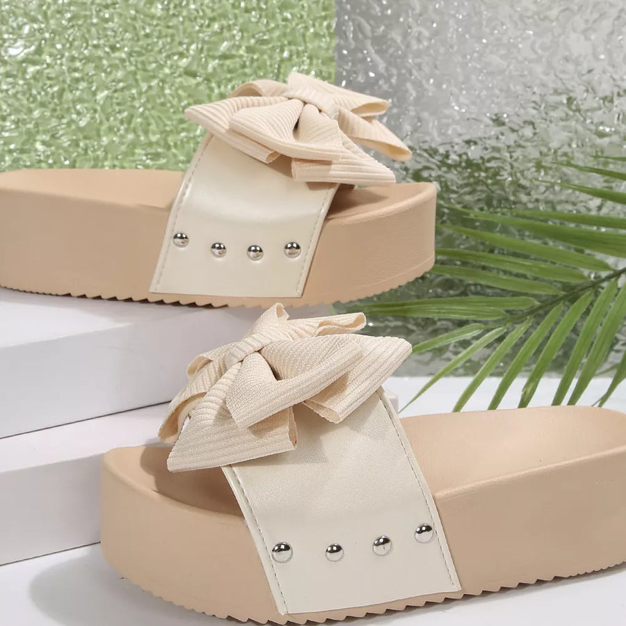 Ribbed bow accent platform sandals in white with beige sole and silver studs.