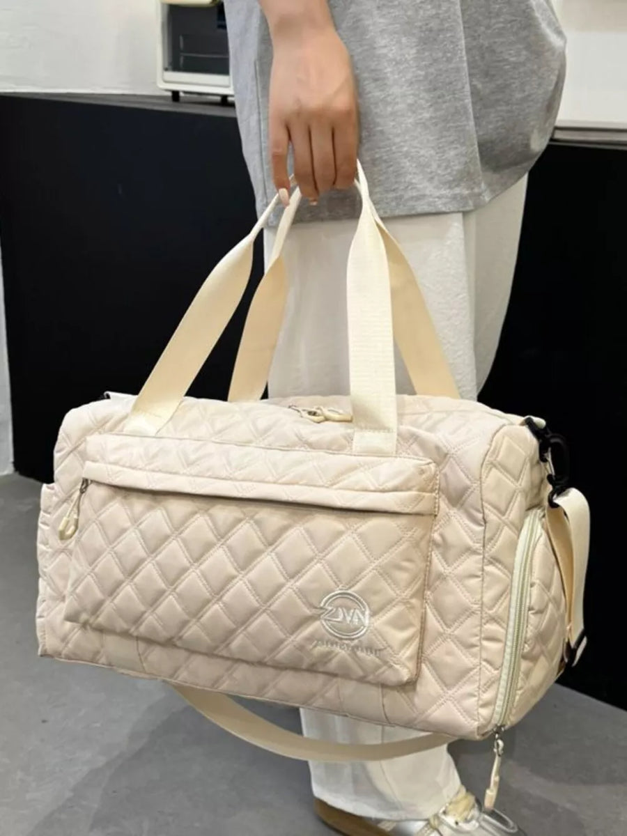 Diamond-quilted travel bag in off-white with versatile straps and front pocket detail.