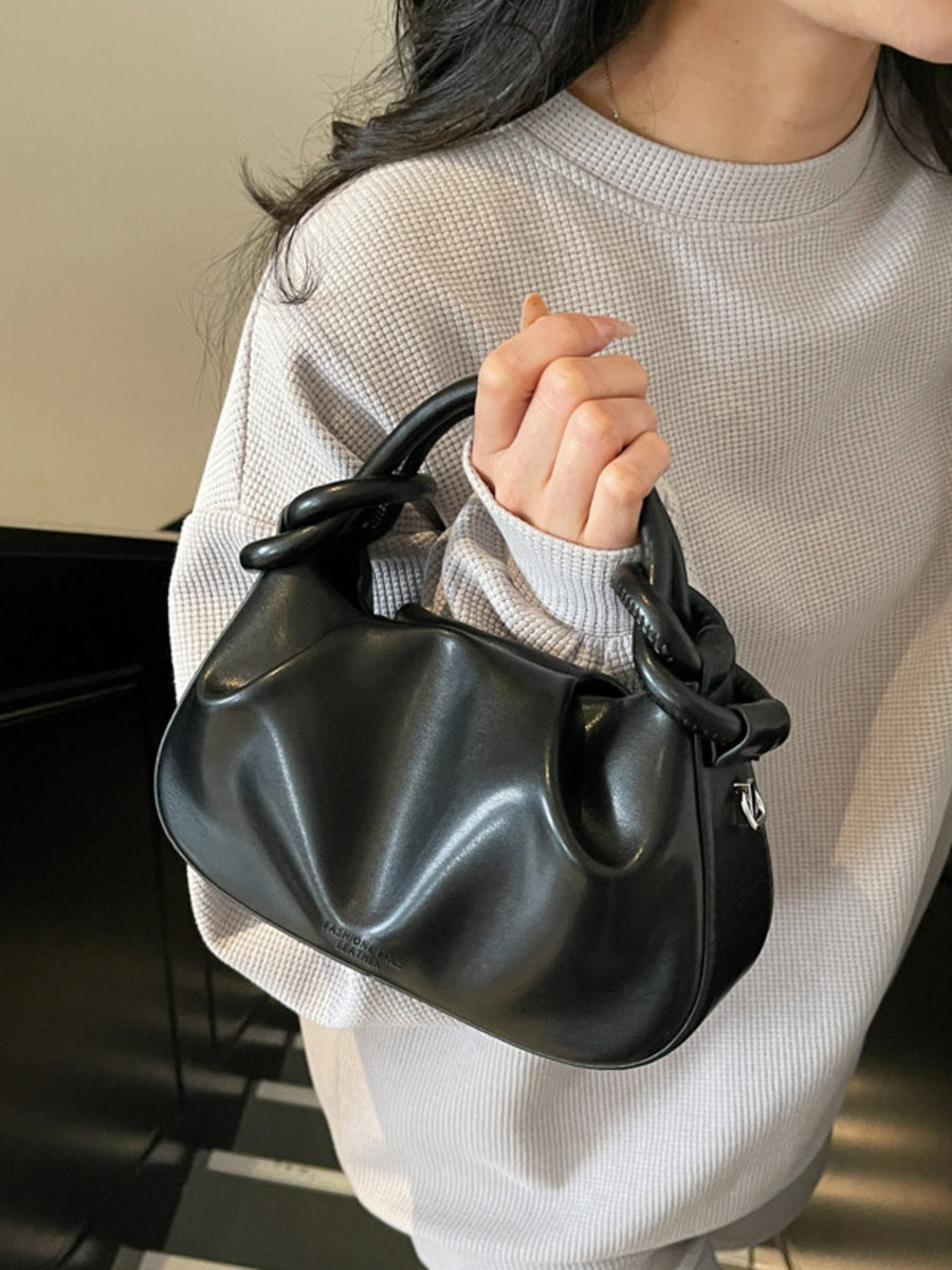 Black ruched crossbody bag with knot handle and adjustable strap