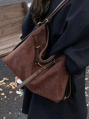 Chic brown suede tote bag with leather trim and gold hardware.