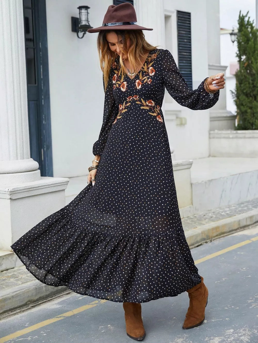 Black polka dot maxi dress with embroidered floral detail, V-neck, long sleeves, and ruffled hem.