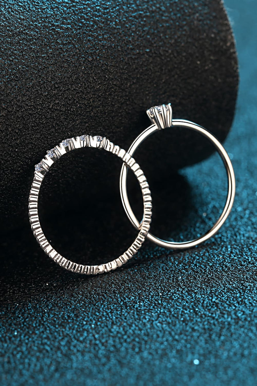 Silver layered ring set with moissanite accents and a solitaire ring.