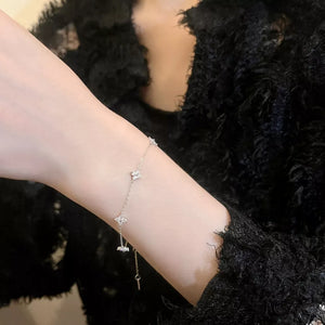 Gold and silver bracelet with clover charms and a key dangle