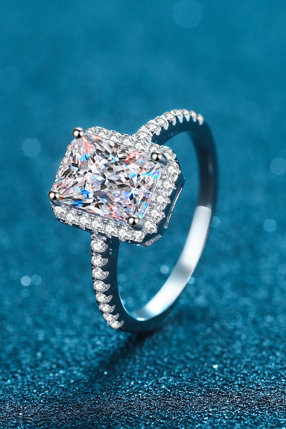 Radiant cushion cut halo ring in silver with sparkling cubic zirconia stones.