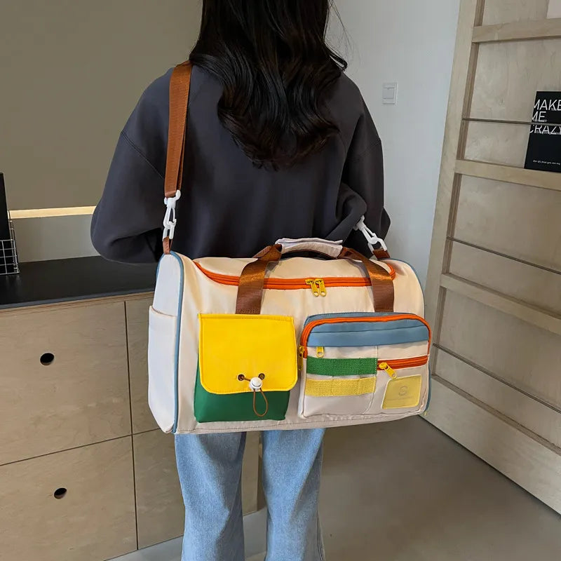 Beige duffel bag with bright colorblock pockets and brown straps