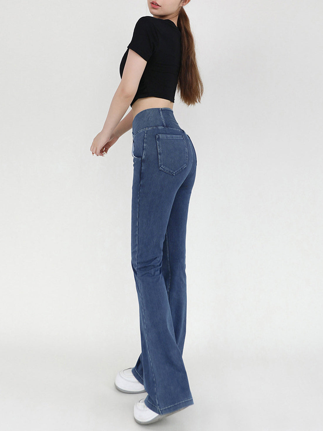 Medium wash denim flare jeans with crossover waist detail.